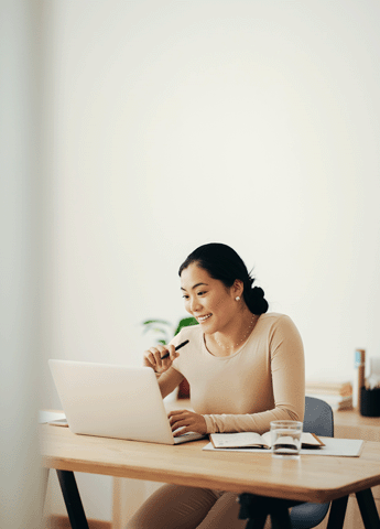 sales professional smiling and working on laptop