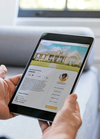 Person holding tablet showing real estate website