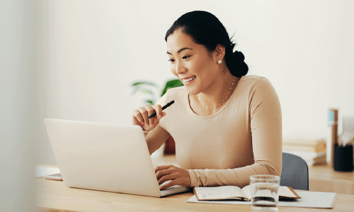 sales professional smiling and working on laptop