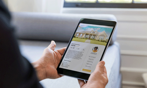 Person holding tablet showing real estate website